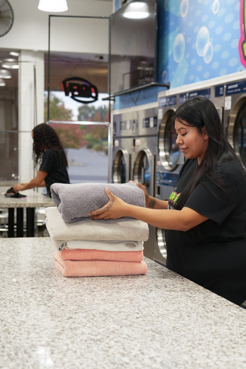 Fresh Rinse staff folding laundry — professional wash and fold service